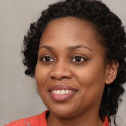 Joyful black young-adult female with long  brown hair and brown eyes