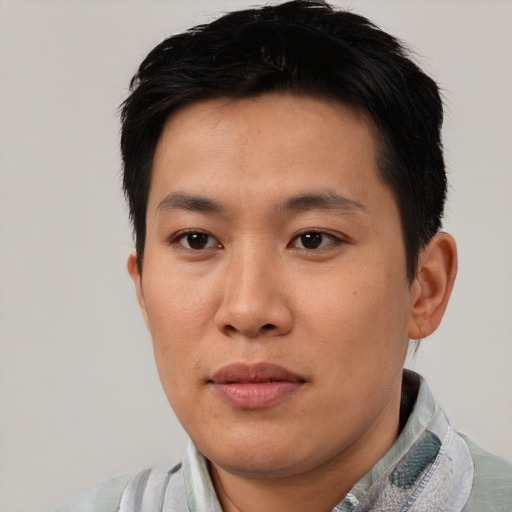 Joyful asian young-adult male with short  black hair and brown eyes