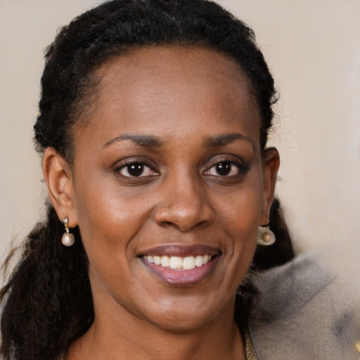 Joyful black young-adult female with long  brown hair and brown eyes