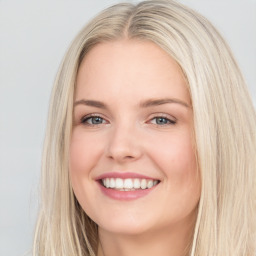 Joyful white young-adult female with long  brown hair and blue eyes