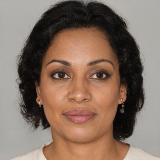 Joyful black adult female with medium  brown hair and brown eyes