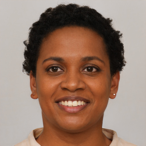Joyful black young-adult female with short  brown hair and brown eyes