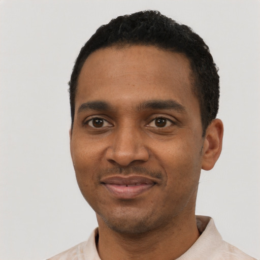 Joyful black young-adult male with short  black hair and brown eyes