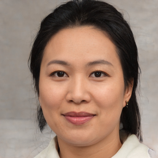 Joyful asian adult female with medium  brown hair and brown eyes