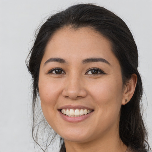 Joyful latino young-adult female with long  brown hair and brown eyes