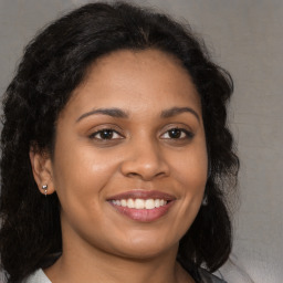 Joyful black young-adult female with long  brown hair and brown eyes