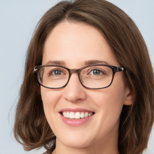 Joyful white young-adult female with long  brown hair and green eyes