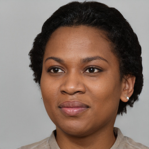 Joyful black young-adult female with short  black hair and brown eyes