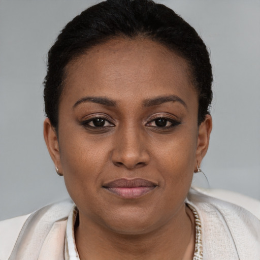 Joyful black young-adult female with short  brown hair and brown eyes