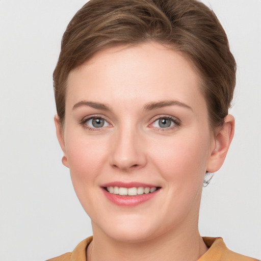 Joyful white young-adult female with short  brown hair and grey eyes