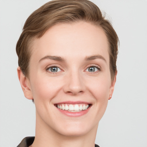 Joyful white young-adult female with short  brown hair and grey eyes