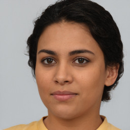 Joyful latino young-adult female with medium  brown hair and brown eyes