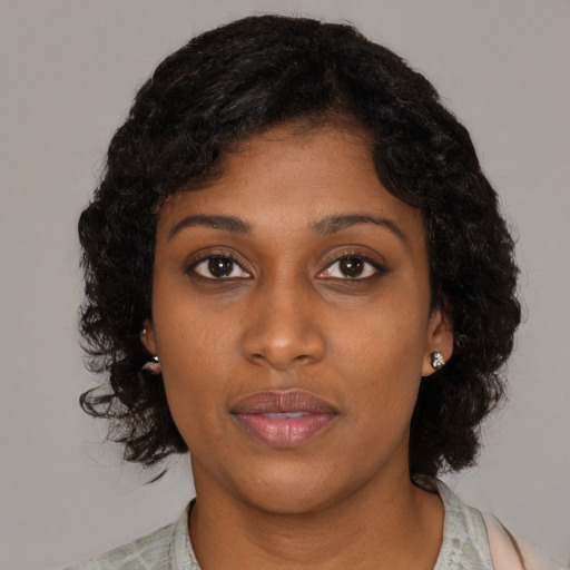 Joyful black young-adult female with medium  brown hair and brown eyes