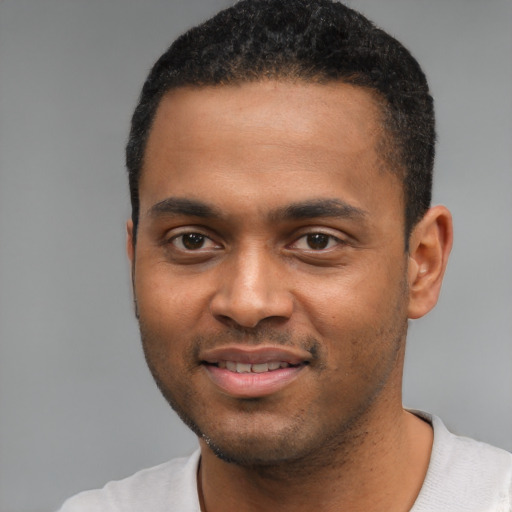 Joyful black young-adult male with short  black hair and brown eyes