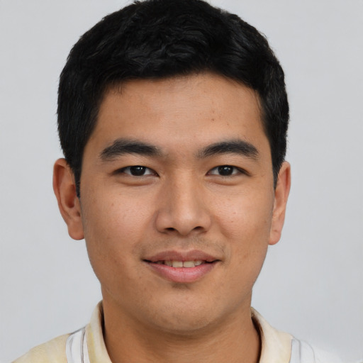 Joyful latino young-adult male with short  black hair and brown eyes