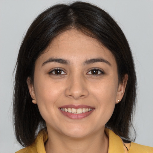 Joyful latino young-adult female with medium  brown hair and brown eyes