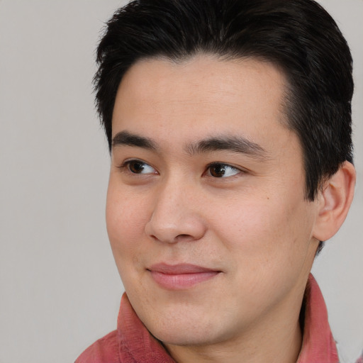 Joyful asian young-adult male with short  brown hair and brown eyes
