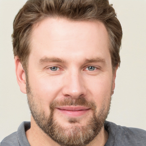 Joyful white adult male with short  brown hair and grey eyes