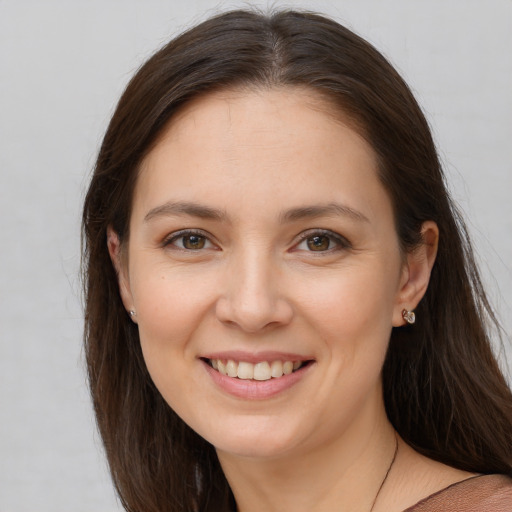 Joyful white young-adult female with long  brown hair and brown eyes