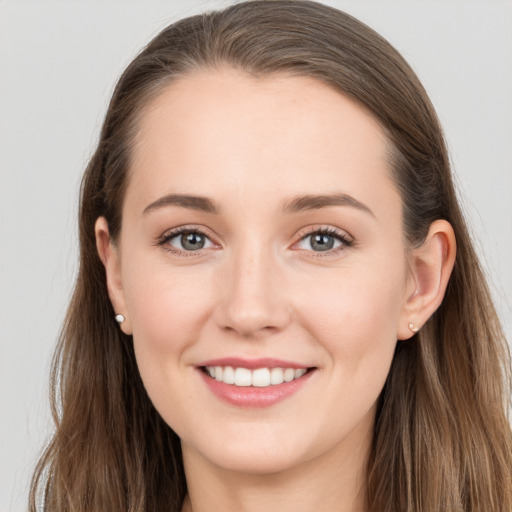 Joyful white young-adult female with long  brown hair and grey eyes