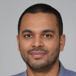 Joyful latino young-adult male with short  black hair and brown eyes