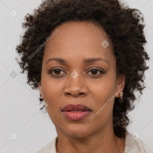 Joyful black adult female with medium  brown hair and brown eyes