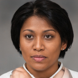 Joyful black young-adult female with medium  brown hair and brown eyes