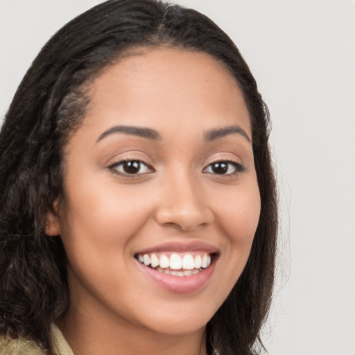 Joyful latino young-adult female with long  brown hair and brown eyes