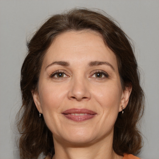 Joyful white adult female with medium  brown hair and brown eyes