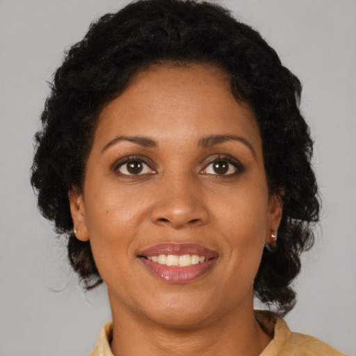 Joyful black young-adult female with medium  brown hair and brown eyes