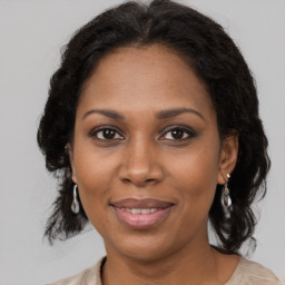 Joyful black adult female with medium  brown hair and brown eyes