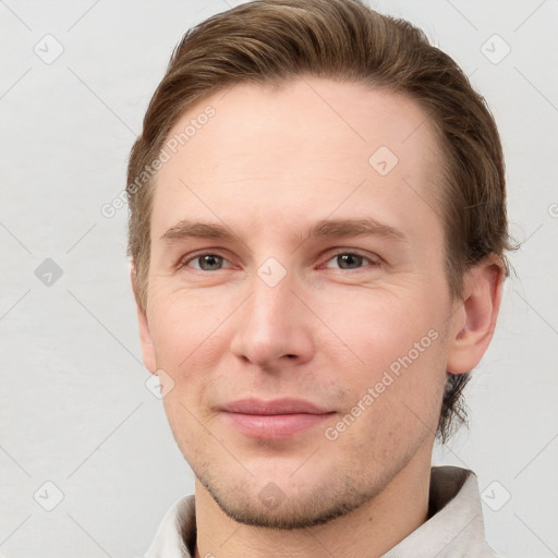 Joyful white young-adult male with short  brown hair and grey eyes