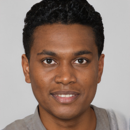 Joyful black young-adult male with short  black hair and brown eyes