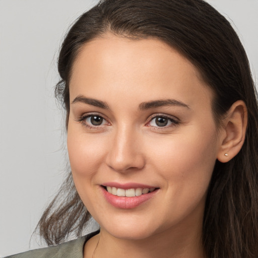 Joyful white young-adult female with long  brown hair and brown eyes