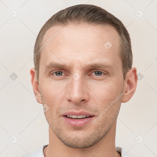 Joyful white young-adult male with short  brown hair and grey eyes