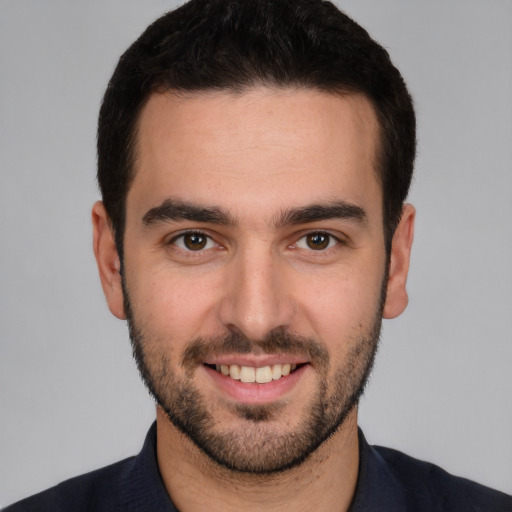 Joyful white young-adult male with short  black hair and brown eyes