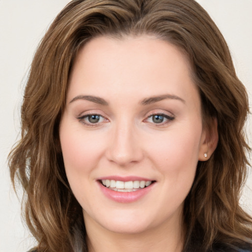 Joyful white young-adult female with long  brown hair and blue eyes