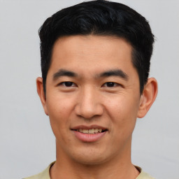 Joyful asian young-adult male with short  black hair and brown eyes