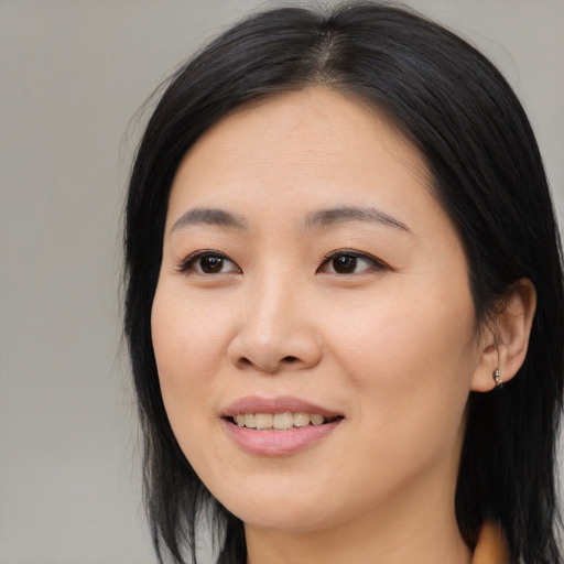 Joyful asian young-adult female with medium  black hair and brown eyes