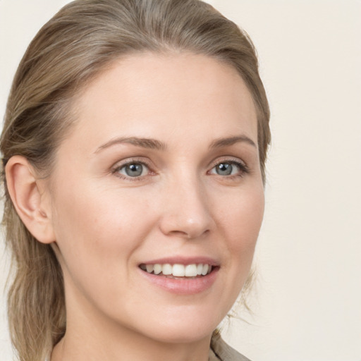 Joyful white young-adult female with medium  brown hair and grey eyes