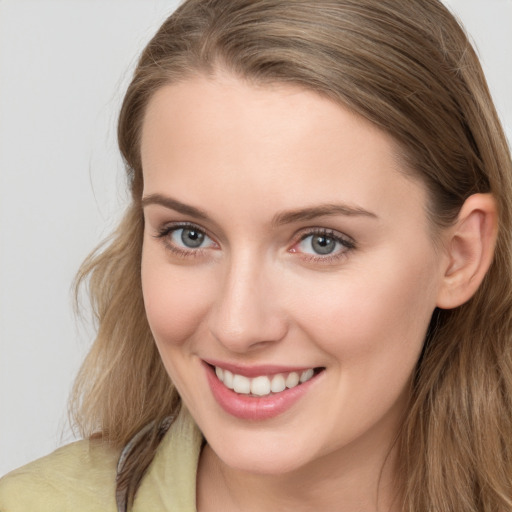 Joyful white young-adult female with long  brown hair and blue eyes