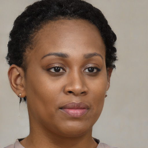 Joyful black young-adult female with short  brown hair and brown eyes