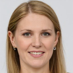 Joyful white adult female with long  brown hair and grey eyes