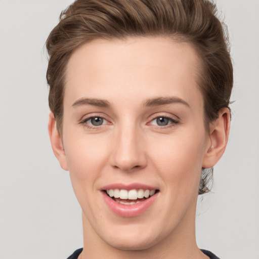 Joyful white young-adult female with short  brown hair and grey eyes