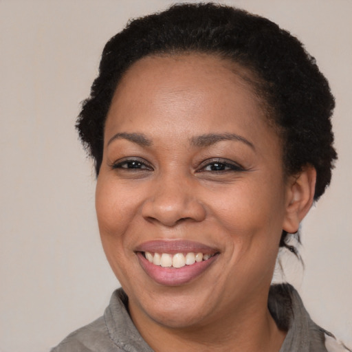 Joyful black adult female with short  brown hair and brown eyes