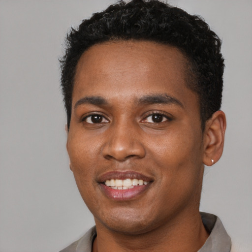 Joyful black young-adult male with short  brown hair and brown eyes