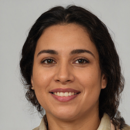 Joyful latino adult female with medium  brown hair and brown eyes