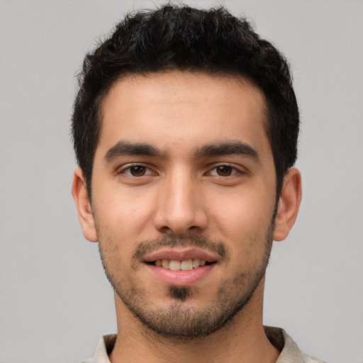 Joyful white young-adult male with short  black hair and brown eyes