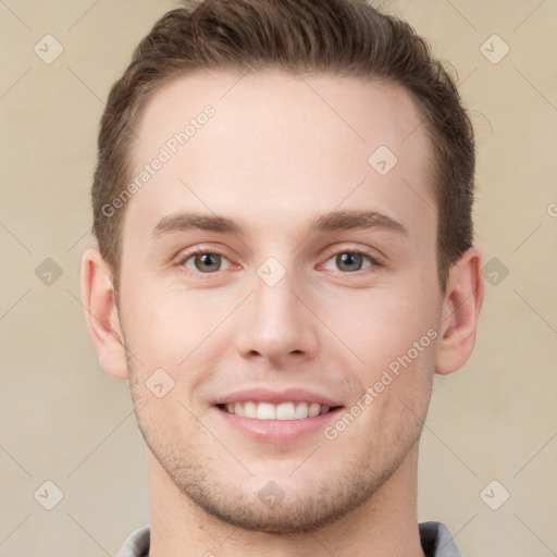 Joyful white young-adult male with short  brown hair and grey eyes