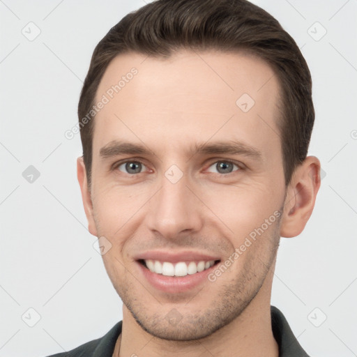 Joyful white young-adult male with short  brown hair and grey eyes